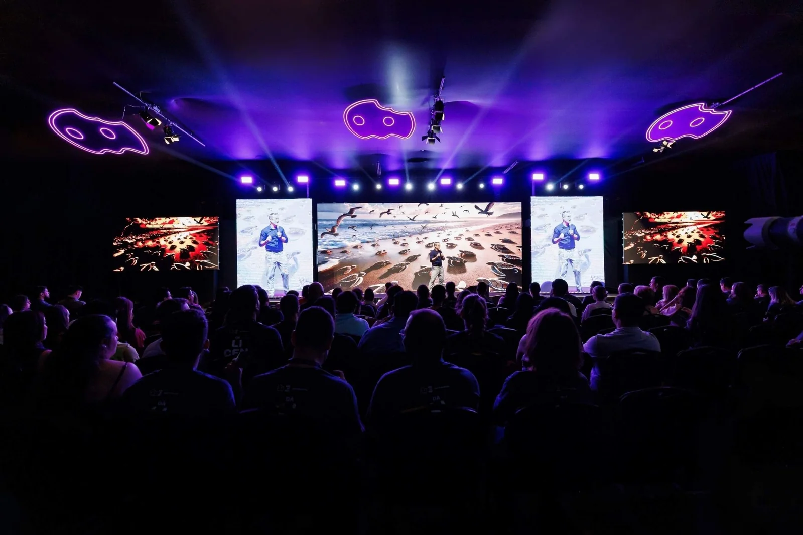Palco do Aiqfome Dá Licença 2024 em Minas Gerais, com plateia e fantasmas em neon
